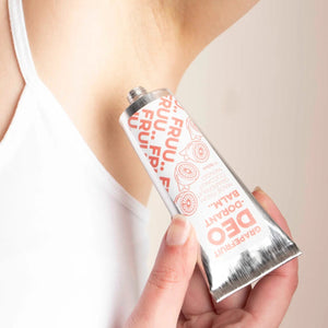 Person applying FRUU Grapefruit & Juniper Deodorant Balm to underarm – creamy, aluminium-free natural deodorant for sensitive skin.