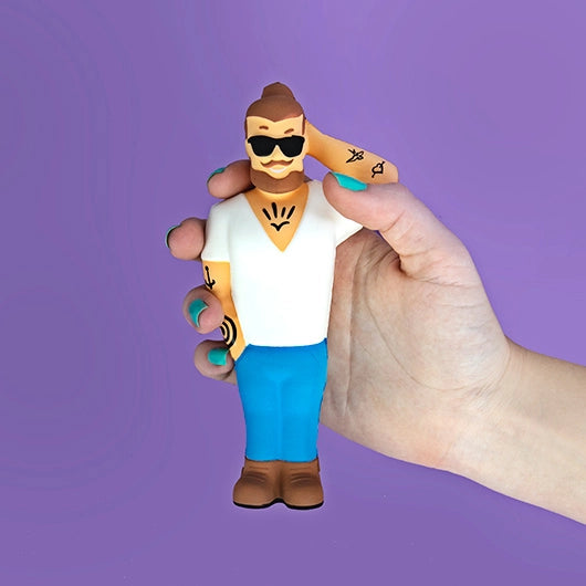 Hand squeezing F**kboy Stress Toy squishy figure with man bun and tattoos.