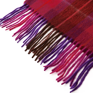 Close-up of fuchsia red tartan lambswool scarf fringed tassels in red, purple, and brown.