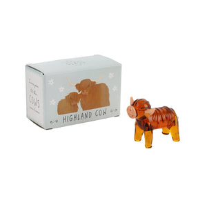 Glass Highland Cow Ornament with gift box – A glass Highland cow ornament displayed alongside its decorative gift box featuring an illustration of two Highland cows.