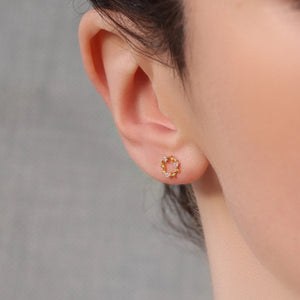 Gold wreath circle stud earring worn on an ear, showcasing the elegant size, Art Nouveau-inspired leaf pattern, and clear crystal sparkle.