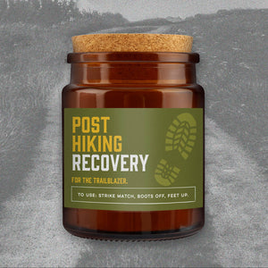 Great Plains Post Hiking Recovery candle in brown glass jar with cork lid and green label reading For the Trailblazer.