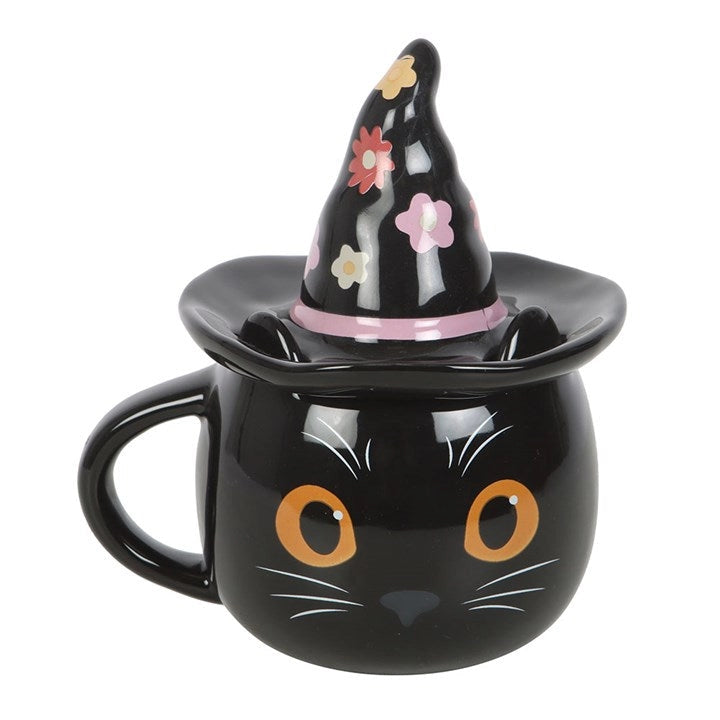 Ceramic cat mug with witch hat lid featuring retro floral design and orange eyes, displayed on white background.