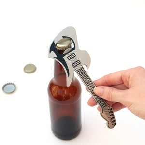 Stainless steel guitar bottle opener in use on a beer bottle.