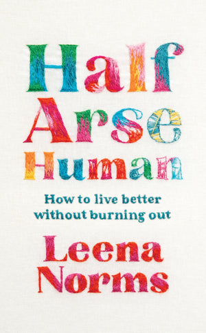 Cover of Half Arse Human by Leena Norms, featuring colourful embroidered text on a cream fabric background. The subtitle reads, “How to live better without burning out.