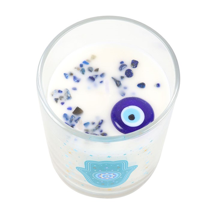 Top view of Hand of Hamsa candle showing blue crystal chips and evil eye charm embedded in white wax.