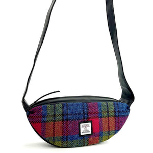 Front view: Harris Tweed Sling Bag in blue & pink, highlighting the bag's dimensions, vegan leather trim and Harris Tweed Orb trademark badge.