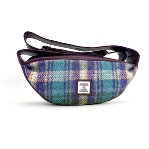 Front view: Harris Tweed Sling Bag in green & purple, highlighting the bag's dimensions, vegan leather trim and Harris Tweed Orb trademark badge.