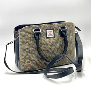 Harris Tweed Top Handle Bag in Country Green, featuring Black vegan leather trim. Showing the long strap for this dual use bag.