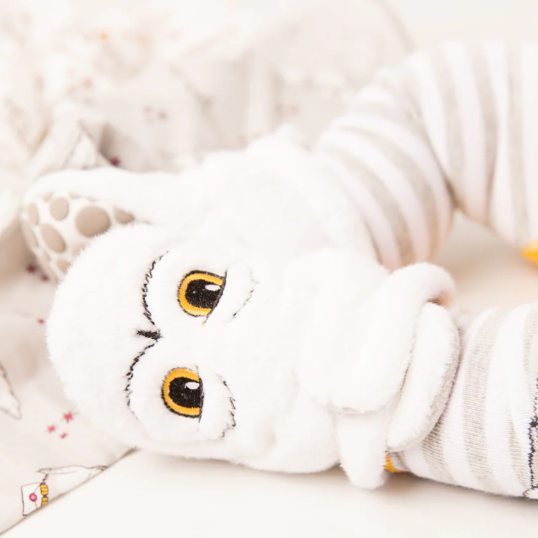 Close-up of Harry Potter™ Hedwig Baby Booties with embroidered owl face in white and grey fleece.