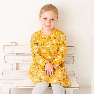Child smiling in Harry Potter™ Hedwig Dress featuring Hedwig and lightning bolt motifs.