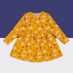 Flat lay of Harry Potter™ Hedwig Dress in mustard yellow with Hedwig, wands, and HP icons on purple background.