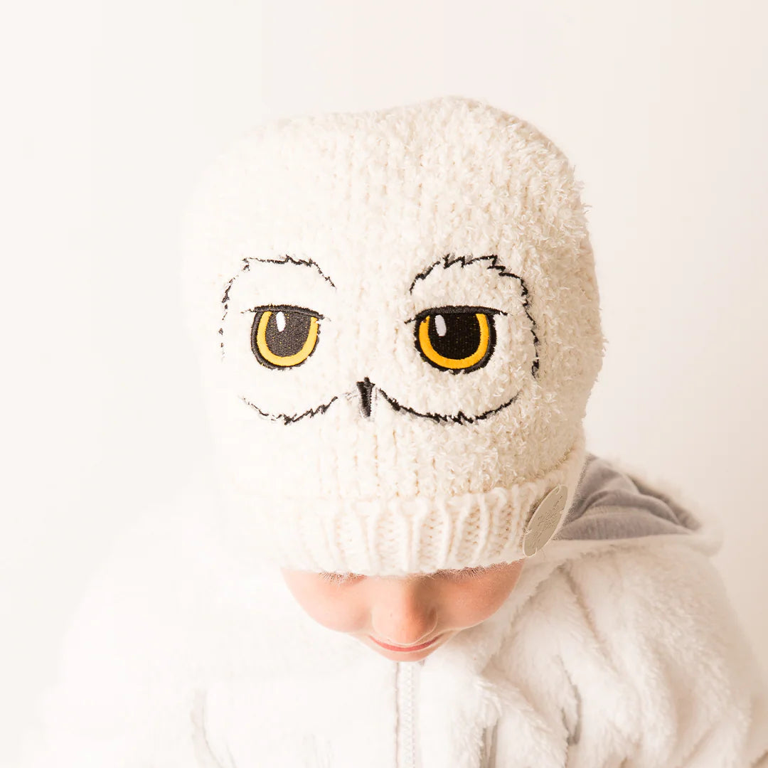 Child wearing Harry Potter™ Hedwig Winter Hat – white knit beanie with embroidered owl face design.