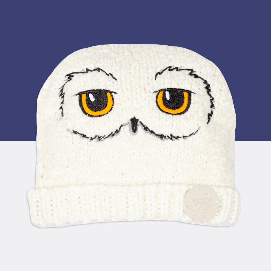 Harry Potter™ Hedwig Winter Hat flat lay – white knit beanie with embroidered owl eyes and beak.
