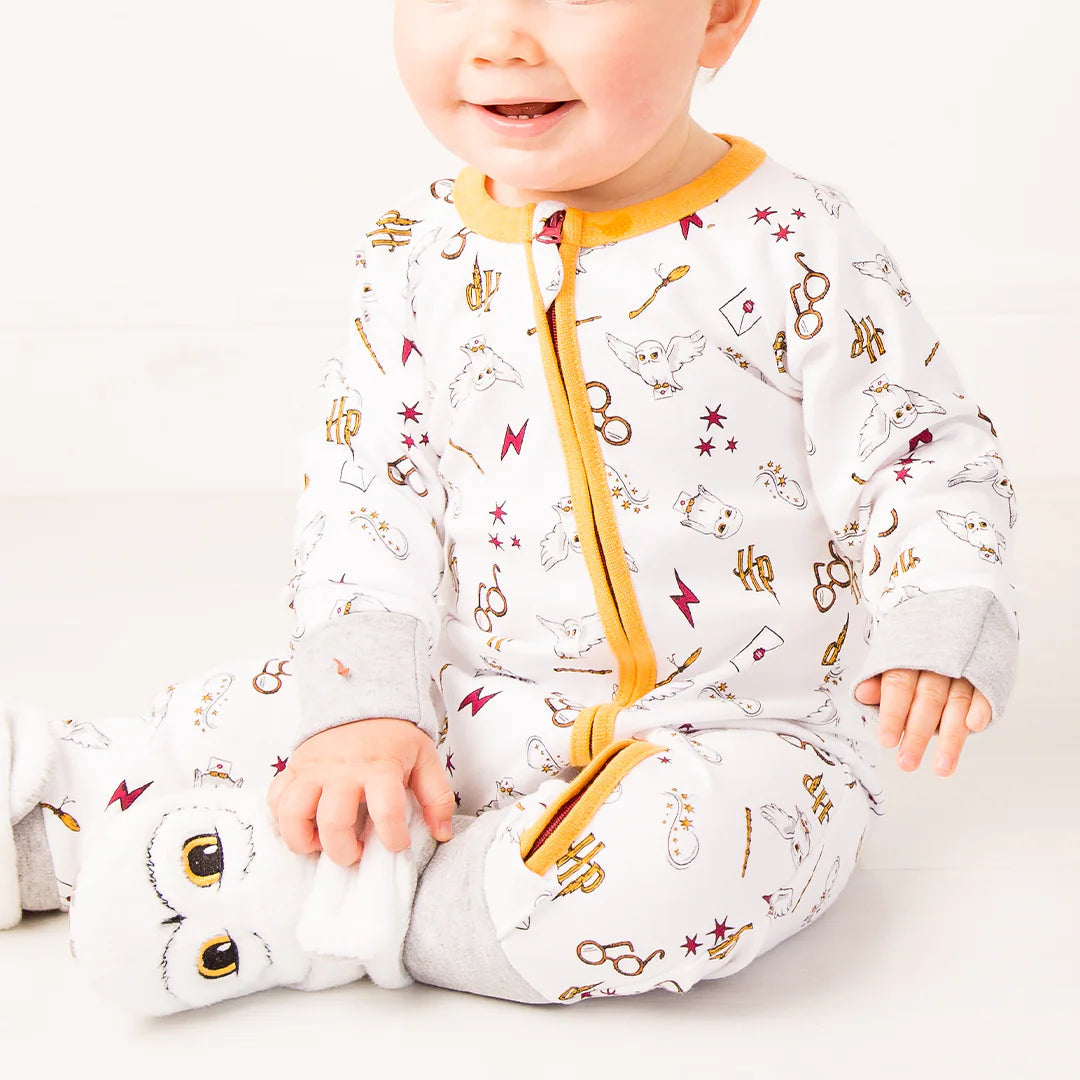 Baby wearing Harry Potter™ Hedwig romper playsuit with magical motif print and yellow zip.