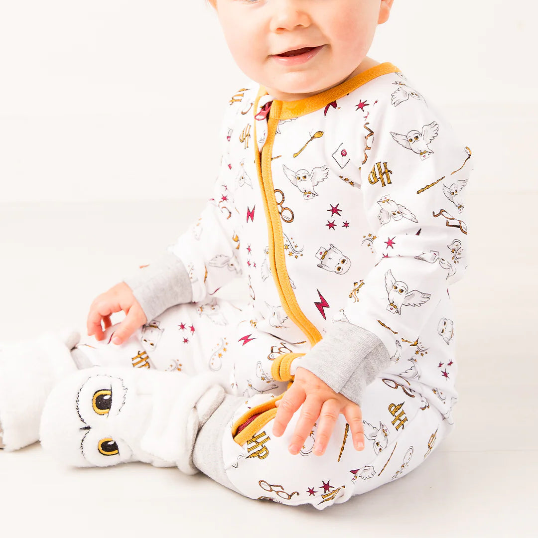 Baby sitting in Harry Potter™ Hedwig cotton romper with fold-over cuffs.