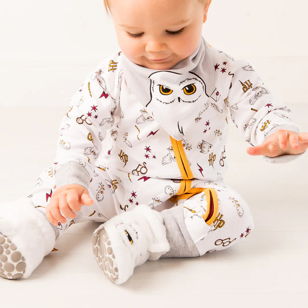 Baby looking down while wearing Harry Potter™ Hedwig romper playsuit with grey cuff details.