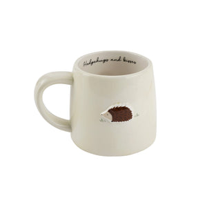 Ceramic hedgehog mug with slogan Hedgehugs and Kisses inside rim.