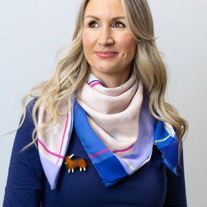 Model Holding the Scarf Ends – A close-up of the Hairy Coo Thistle Scarf being showcased, highlighting the soft, sustainable Repreve material and vibrant colour details.