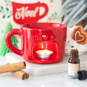 Festive mug-shaped Christmas oil burner with tealight inside, heart-shaped cut-outs glowing.