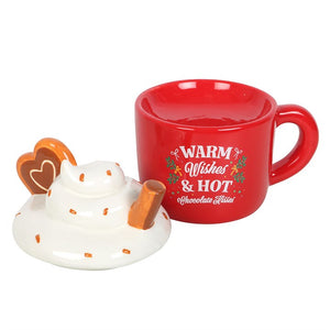 Christmas oil burner with removable whipped cream-style lid beside festive red mug base.