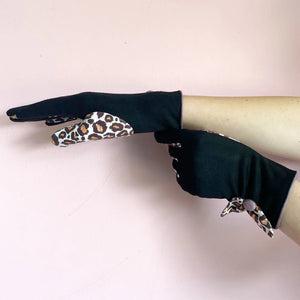 Side view of animal print purple leopard gloves with leopard pattern on thumb and bow detail.