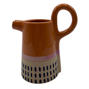Front view of Bloc Jug with glossy orange top, hand-painted base, and pink band.