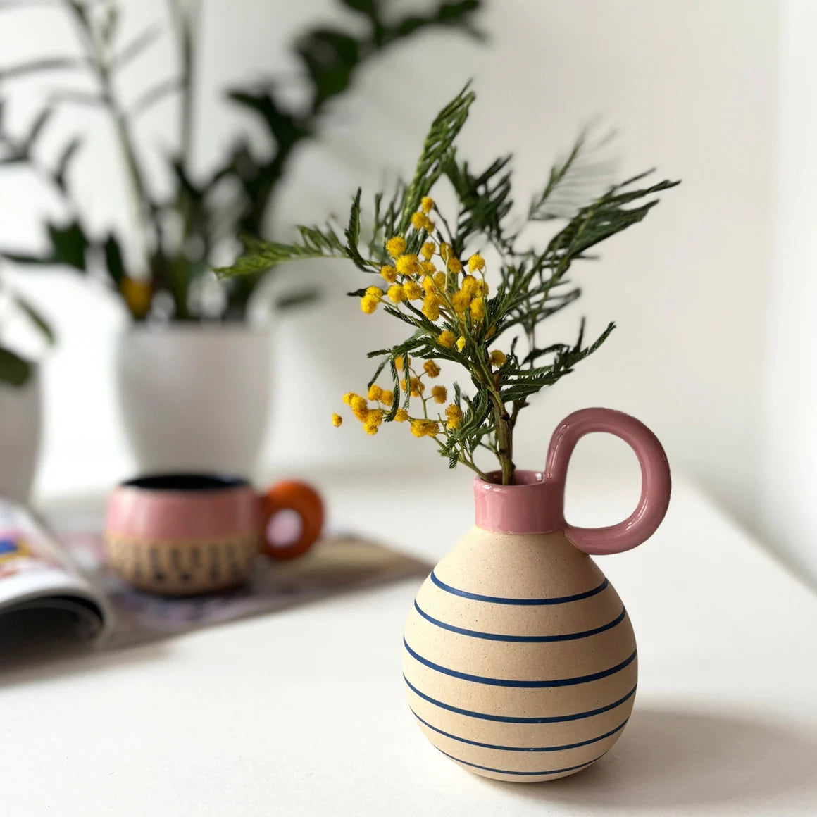 Side angle of the Bloc Vase highlighting its curved rectangular shape and colourful geometric patterns including circles, lines and solid blocks of pink, mint and navy.