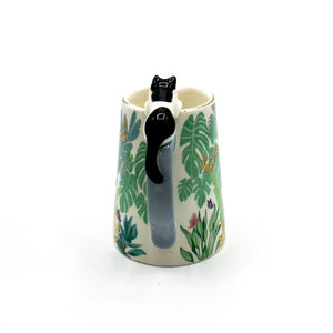 Rear view of the Boulevard Cat Jug showing full tail of ceramic cat wrapped around the handle, surrounded by green botanical pattern.
