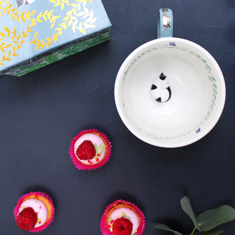 Top view of porcelain Greenhouse cup with hidden cat figure and delicate inner vine print.