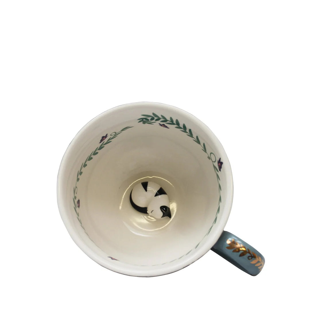 Overhead view of Greenhouse cup revealing sculpted cat and butterfly motif inside.