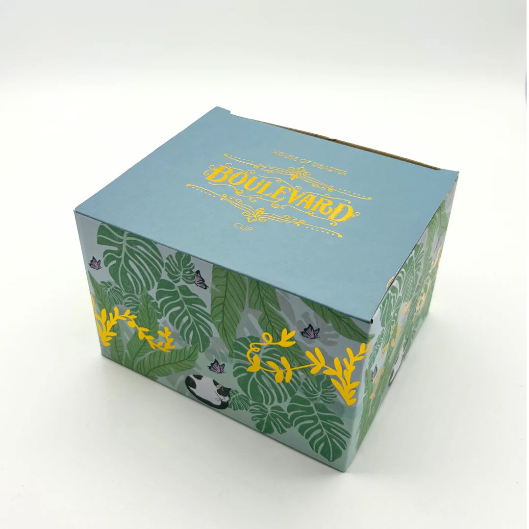 Decorative gift box for Boulevard Greenhouse Cup with tropical leaf and gold foil design.