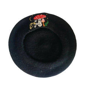 Rear view of Forage black beret showing full embroidered toadstool and fern motif – nature-inspired embroidered hat for autumn and winter style.