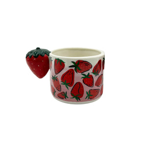 Front view of ceramic mug featuring red strawberry print and detailed 3D strawberry handle on white background.