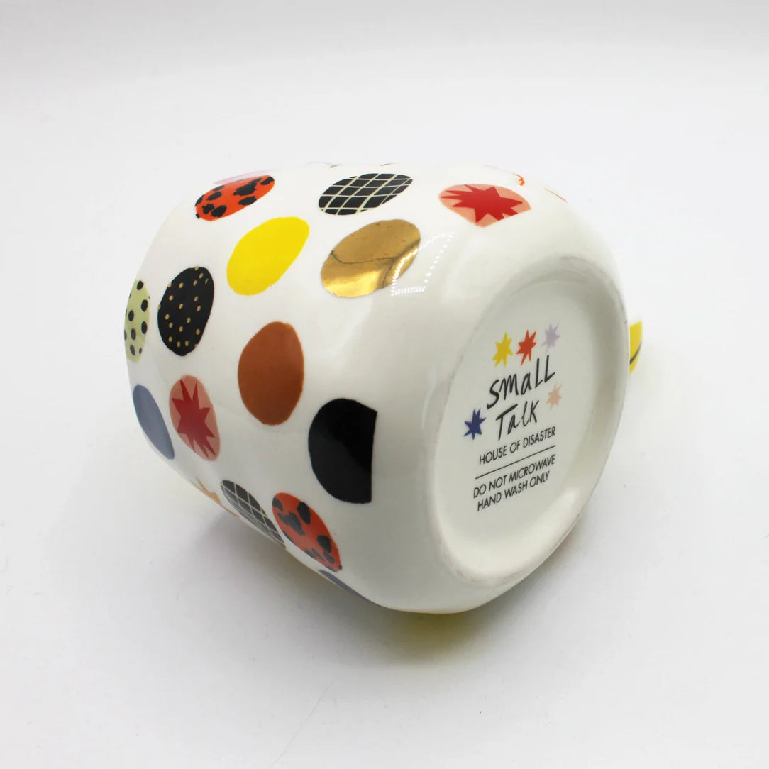 Underside of ceramic mug showing Small Talk branding, care instructions, and gold polka dot detail.