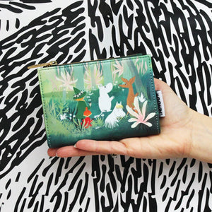 Hand holding the Moomin Forest Purse to show size and scale, featuring detailed illustrated characters on the front.