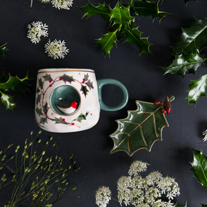 Secret Garden robin mug styled with matching ceramic holly leaf dish and festive foliage.