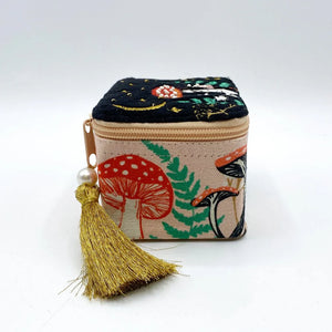 Side view of the trinket box showcasing printed foliage patterns and a gold satin tassel.