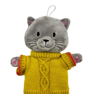 Front view of the House of Disaster Cat Hot Water Bottle in a mustard jumper.