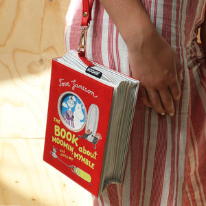 A person wearing the Moomin Book Bag as a crossbody, showcasing its adjustable strap and book-style design.