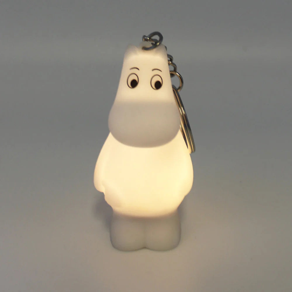 Close-up of a Moomin keyring glowing in the dark, highlighting its soft illumination.