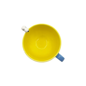 A top-down view of the Snoopy ‘Be Happy’ Cup, highlighting the bright yellow interior and the 3D Snoopy figure hanging from the rim.