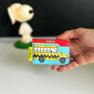 Hand holding the Peanuts Bus Cardholder, showcasing its compact size and retro school bus design.