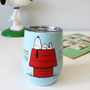 A side view of the travel mug featuring Snoopy lying on his red doghouse, with the text “I’m Allergic to Mondays” wrapping around.