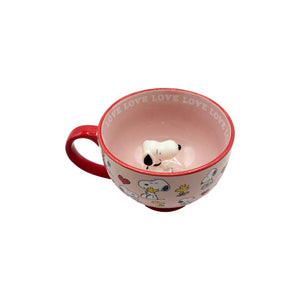 A slightly angled top view of the mug, revealing the inner Snoopy figurine and pink interior.