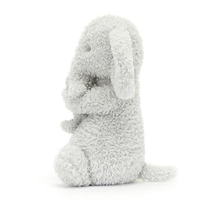 Side View: Jellycat Huddles Grey Elephant standing on its side, showcasing its perfect size (26 cm x 14 cm) for little ones to cuddle. The side profile reveals the depth of the plush, the softness of the fur, and the loving embrace between the elephants.