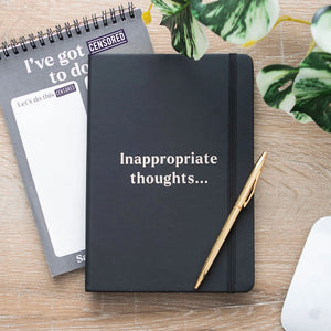 Flat lay of Inappropriate Thoughts A5 Notebook with gold pen on wooden desk, next to censored to-do pad – perfect funny gift for stationery lovers.