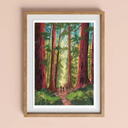 Into the Trees Version 2 art print A4 by Charis Raine Illustration framed on wall, featuring giant redwood trees and woodland path.
