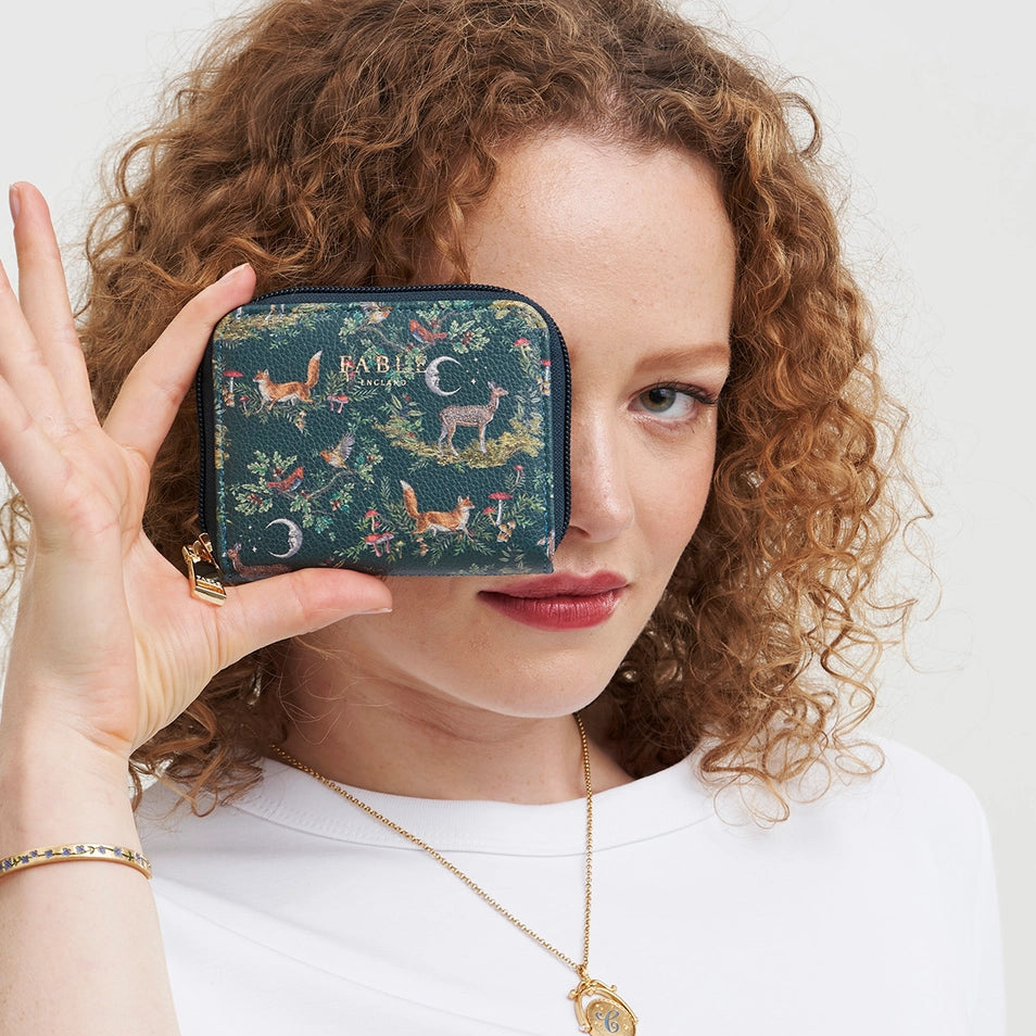 Model holding Into the Woods Green Small Purse with forest print.