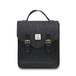 Front image of the Islander Calton backpack showing the black PU leather, buckles on the front of the bag and the top handle.